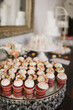 Elegant red velvet cupcakes on a mirrored stand.