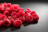 Fototapeta  - Raspberry fresh berries closeup, ripe fresh organic Raspberries over black background, macro shot. Harvest concept