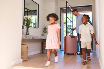 Multi Racial Family With Father And Children Arriving In House Or Apartment For Summer Vacation