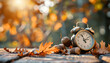 © Oleksiy - Alarm clock, acorns and autumn leaves on table outdoors. Daylight saving time end
