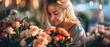A beautiful young woman with blonde hair smiles as she smells a bouquet of roses.