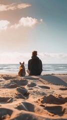 Wall Mural - A person sitting on a beach with a dog