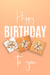 Verical banner with elegant birthday presents and festive text on peach background