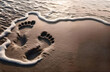 Pisadas de pies en la arena de la playa junto a la orilla, mientras rompe la espuma