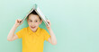 Boy holds book on a head