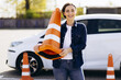 Woman holding big road cone and passing driving test