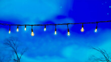Illuminated String Lights Against A Dusk Sky