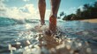 © DWN Media - Close up of a man's feet walking on the beach, closeup of legs in shallow water against a tropical resort background