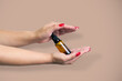 Product package with serum and a woman hand in studio on a backg