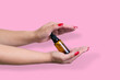 Product package with serum and a woman hand in studio on a backg