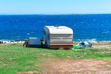 Wall Mural - Caravan trailer on the beach in sunny summer day. Perfect summer coastal vacation 