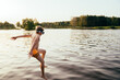 young boy diving into water. Active child splashes inside lake. Kid enjoying summer vacations