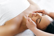 Facial massage concept. Calm relaxed brazilian or hispanic young woman lies at salon during a head massage, smiling. Female massage therapist doing general head massage to a pretty girl