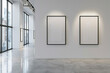 A sleek white art gallery interior featuring an expansive light grey wall adorned with empty matte black frame mock-up posters, illuminated by soft, 