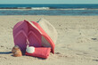 Flip flop, straw hat and towel on beach. Accessories for relax on sand. Summer vacation