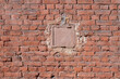 Square small hatch in a old brick wall