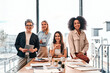 Group of businesspeople.Leadership concept.Four diverse women in a modern office looking at the camera and smiling. Copy space.