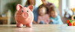 Piggy bank standing on desk with blurred a happy family in background