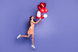 © deagreez - Full length profile portrait of nice lady hold balloons jump empty space wear dress isolated on purple color background