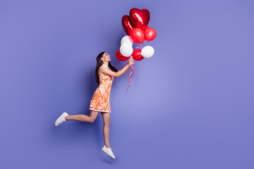 Sticker - Full length profile portrait of nice lady hold balloons jump empty space wear dress isolated on purple color background