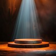 An empty circular stage podium bathed in a dramatic spotlight, awaiting a performance or presentation in a dark venue.