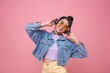 Happy young asian woman listening music with headphone dancing isolated on pink background. People lifestyle relax concept.