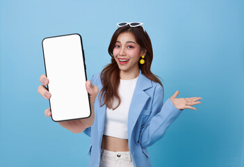 beautiful asian business woman showing smartphone mockup of blank screen isolated on blue background