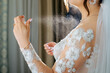 Bride's hand spraying perfume..