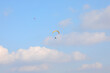 Two people practicing extreme sports with paragliders flying high in the sky, also a symbol of carefreeness