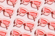 Stylish sunglasses pink color glasses on light pink background, shadow at sunlight, summer fashion eyeglasses. Summer sale concept in optical store. Top view aesthetic pattern, monochromatic
