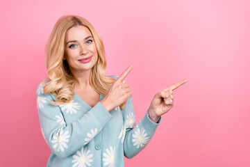 Sticker - Portrait of cheerful person with curly hairstyle wear blue cardigan indicating at promo empty space isolated on pink color background