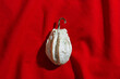 One Pumpkin or gourd of ugly shapes, top view on red textile tablecloth. Autumn flat lay composition with ornamental pumpkin white colored, minimal, sunlight trend shadow, copy space, still life