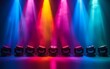 Colorful stage lights illuminate an empty stage.