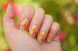 Female hand with beautiful floral manicure. Nail art with cute painted flowers