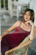 Attractive asian woman in a red dress is posing