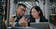 People traveling together at night in train or bus. Sitting down while using digital devices. Man showing funny video to woman. Asian girl smiling and replying back. Man can't hear through earphones.
