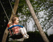 Portrait of a little girl riding on a swing.