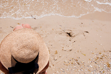 Beach vacation of retro girl. Sea traveling. Woman on summer vacation at beach. Summer vacation of woman in straw hat copy space. Retro woman at sea sand beach. Suntan at summer beach. Advertisement