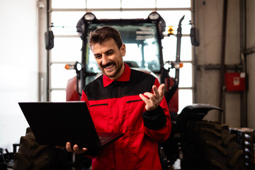 Poster - Professional serviceman holding diagnostic tool and standing by the tractor.