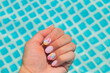 A woman swims in the pool. Female hand with manicure under clean water.