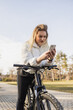 Woman Riding Bike While Looking at Cell Phone
