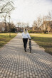 Woman Walking Her Bike Down a Path in Park
