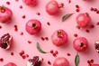 Fresh pomegranates and leaves on a pink background. Ideal for food and healthy lifestyle concepts