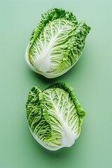 Wall Mural - Two pieces of lettuce on a green surface. Suitable for food and nutrition concepts