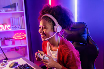 Wall Mural - Host channel of gaming streamer, African girl wining with Esport skilled team player and viewers online game in neon color lighting room. Concept of cybersport indoor activities. Tastemaker.