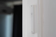 Jewish mezuzah on the doorpost, a prayer for home protection in Judaism. White interior, stylish modern mezuzah in Israel.