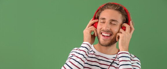 Wall Mural - Handsome man listening to music on color background