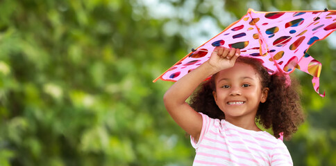 Wall Mural - Little African-American girl flying kite outdoors