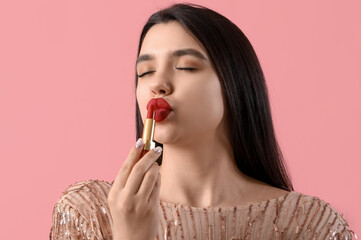 Poster - Beautiful young woman kissing red lipstick on pink background