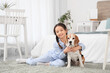 © Pixel-Shot - Cute little Asian girl hugging Beagle dog in bedroom